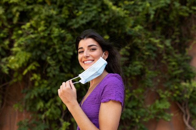 Donna che toglie la maschera dalla vista laterale