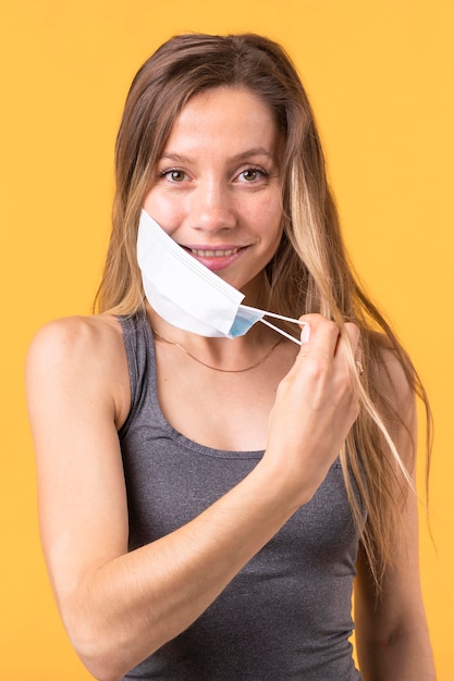 Free photo woman taking off a medical mask