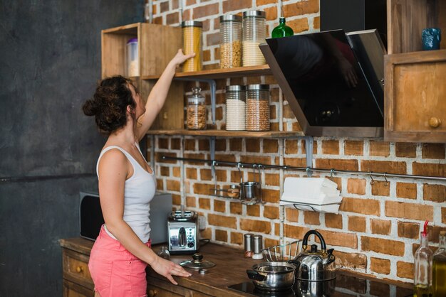 Woman taking pasta from shelf