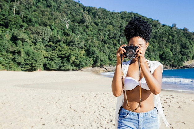 Free photo woman taking a photo at the beach