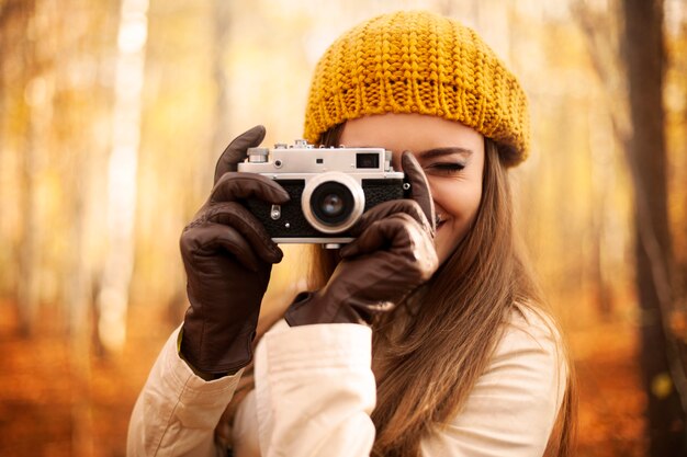 Женщина, делающая фото ретро камерой