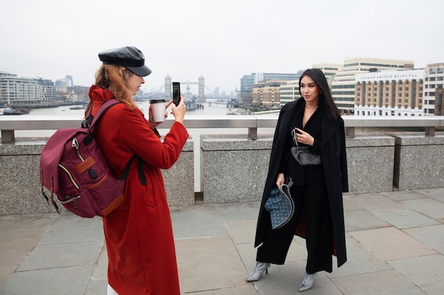 Woman taking photo of influencer on a bridge