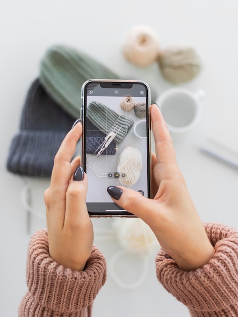 Woman taking photo of knitted caps