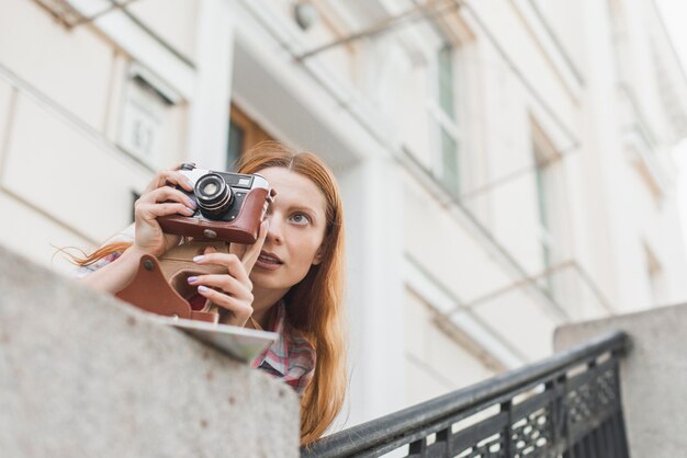 都市のアトラクションの近くの女性が写真を撮る