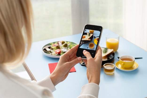 Woman taking photo of pan with egg and toast