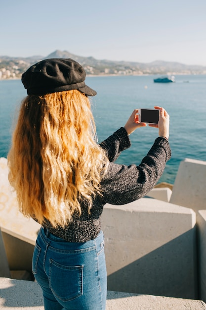Woman taking photo of the sea