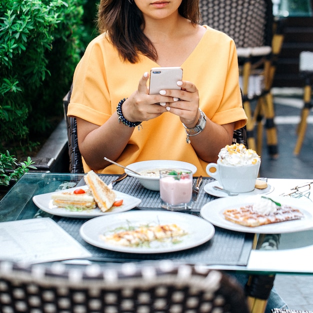 Woman taking photo of table with food