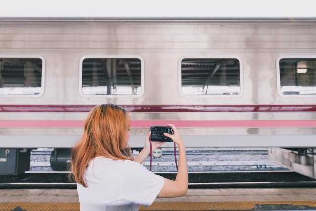 旅行中の電車の写真を撮っている女性