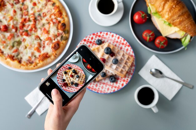 Woman taking photo of waffles with fruits