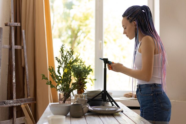 Woman taking photos of ceramic kitchenware