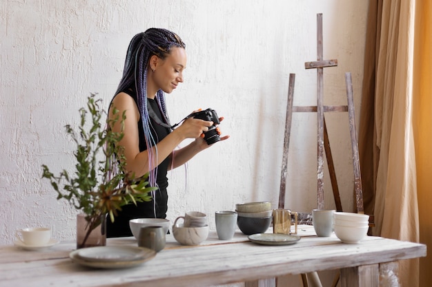 Woman taking photos of ceramic kitchenware