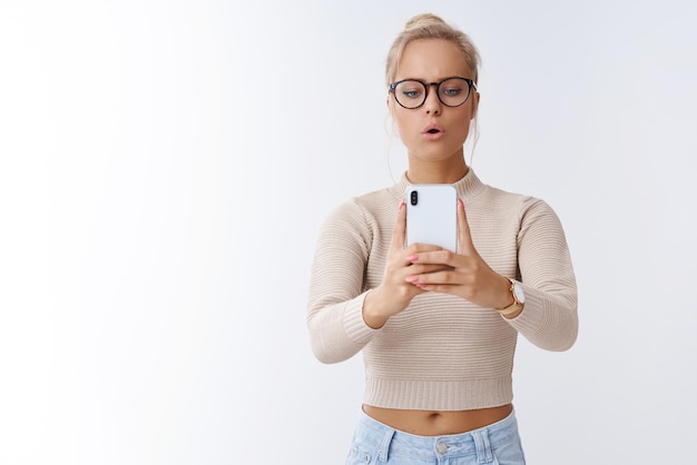 woman taking picture on smartphone making photo open mouth as concentrating