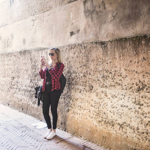 Woman taking pictures on old street