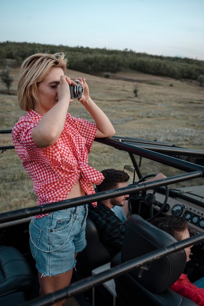 Woman taking pictures while traveling by car