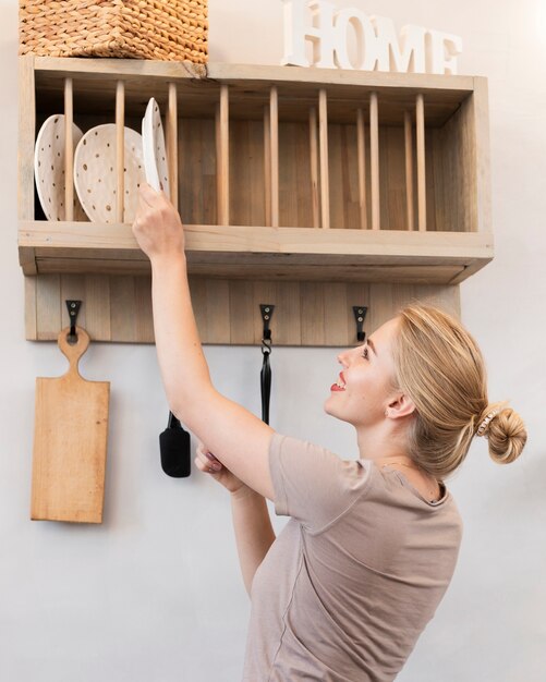 Woman taking a plate from the shelf