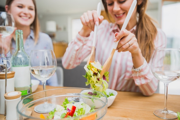 Foto gratuita donna che mangia insalata con amico su priorità bassa