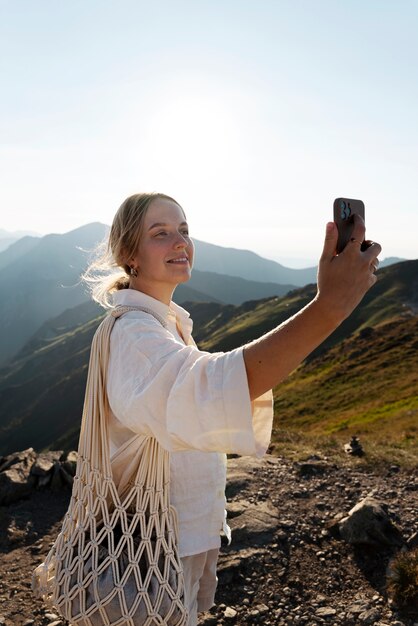 Donna che cattura selfie sulla vista laterale della montagna