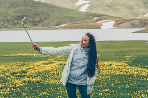 woman taking selfie and smiling at nature