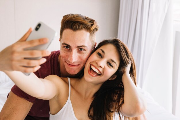 Woman taking selfie with man 