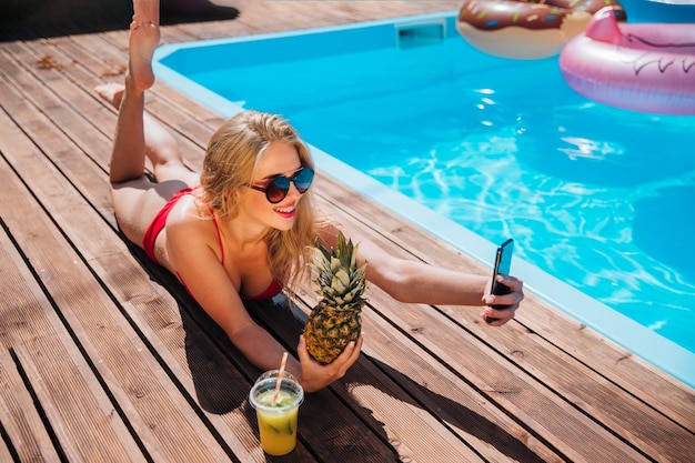 Foto gratuita donna che prende un selfie con un ananas