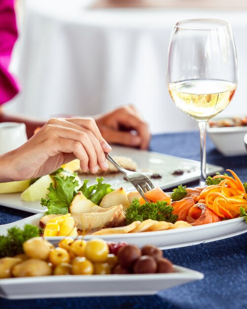 Woman taking smoked salmon from platter