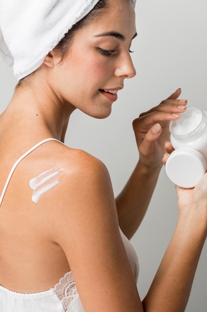 Woman taking some cream from container