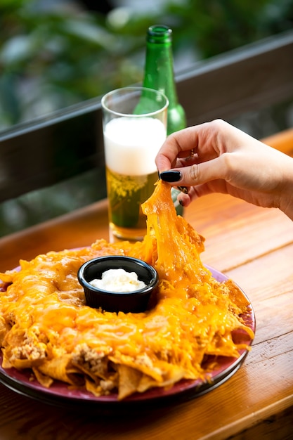 Free photo woman taking tortilla chips mexican chips from plate,