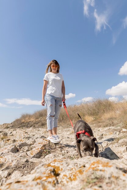 ビーチで犬と散歩をしている女性