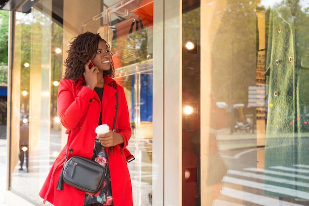 Woman talking by smartphone and looking at showcase