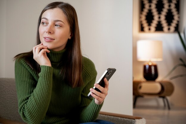 Женщина разговаривает по своему смартфону, используя функцию громкой связи
