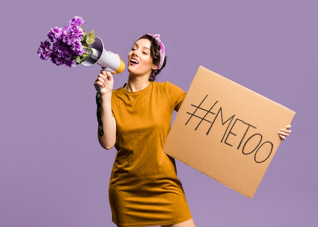 Woman talking on megaphone and holding cardboard with 