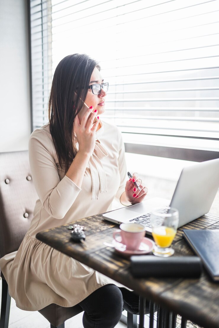 無料Photo コーヒーショップで携帯電話で話す女性