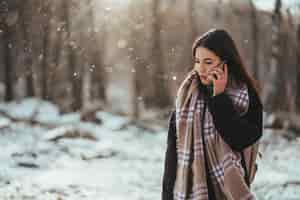 Free photo woman talking on mobile phone. smiling woman talking on mobile phone in cold winter day.