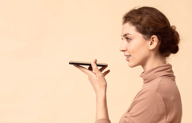 Бесплатное фото Женщина разговаривает по динамику мобильного телефона
