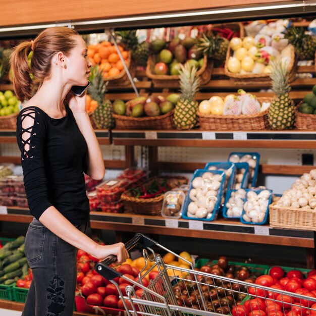 Woman talking on the phone at the grocery store 