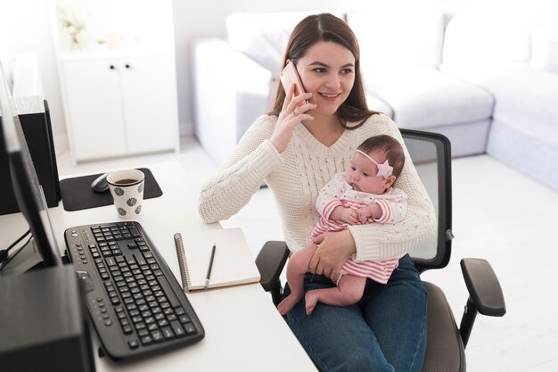 Woman talking on phone and holding daughter
