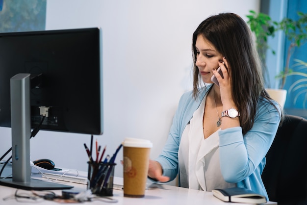 Woman talking on phone in office