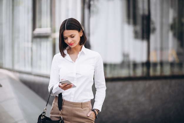 Woman talking on the phone outside the city streets