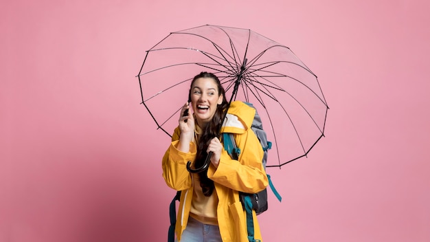 Free photo woman talking on the phone while holding an umbrella