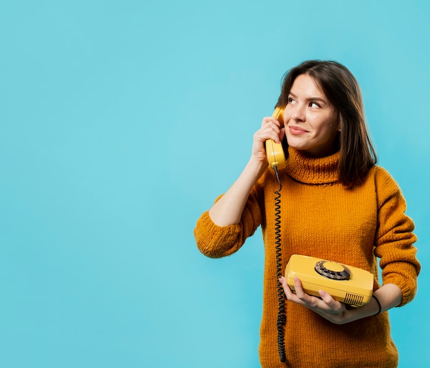 Free photo woman talking at phone with copy space