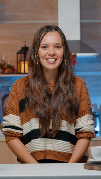 Woman talking on video call in decorated kitchen at home