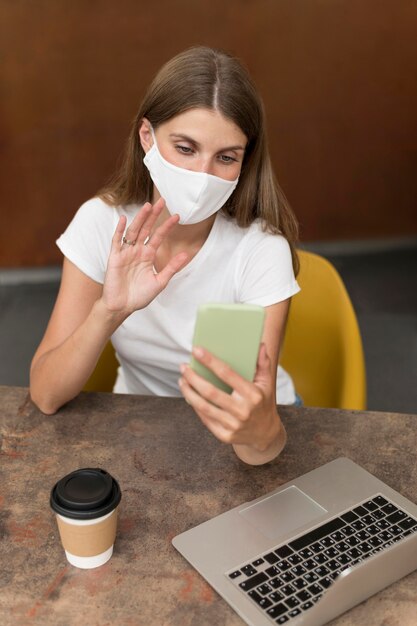 Woman talking on video call with  mask