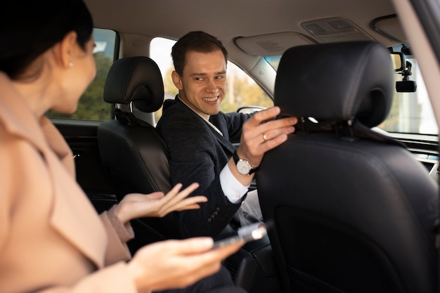 Free photo woman talking with a taxi driver in the car