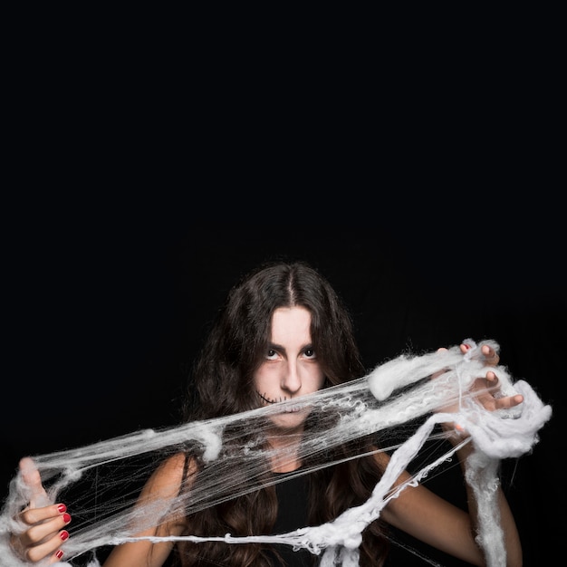 Woman tangling in fake cobweb 