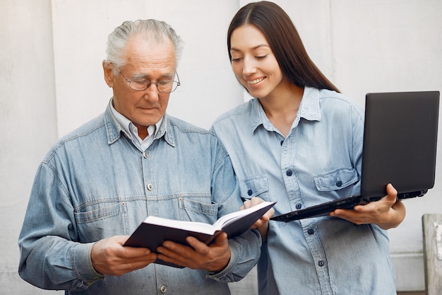 Donna che insegna a suo nonno come usare un computer portatile