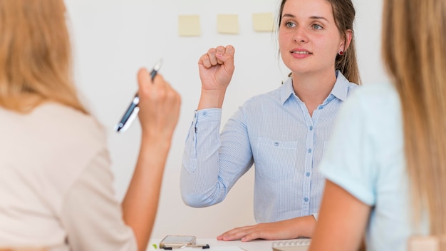 Free photo woman teaching two other people the sign language