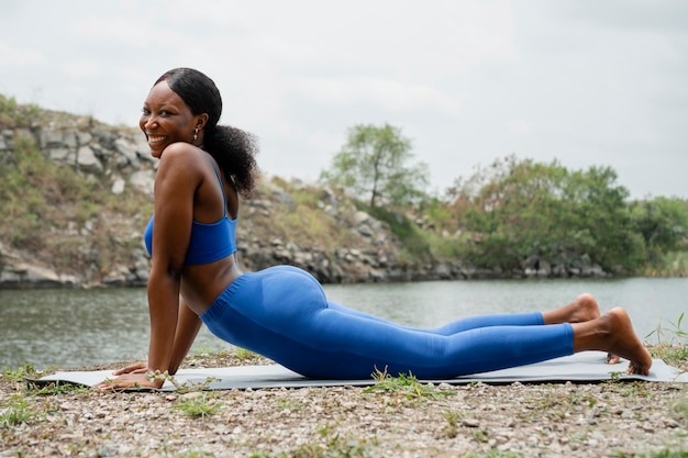 Donna che insegna una posa di yoga all'esterno