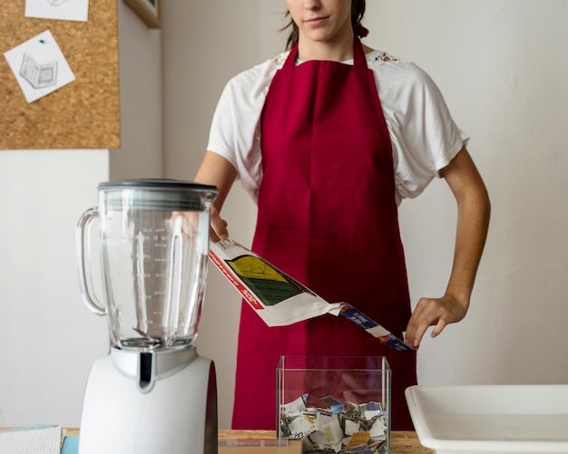 Woman tearing paper with mixer on desk