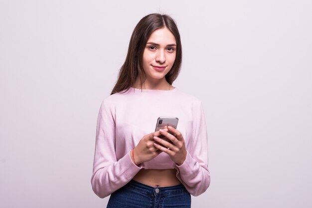 Женщина текстовых сообщений на свой мобильный телефон, изолированных на белом фоне