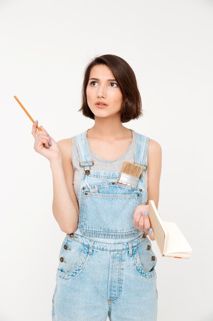 woman thinking as calculating in mind, writing down in notebook